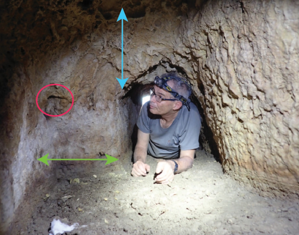 Prof. Amos Frumkin in Tunnel C. General view of meeting point between quarrying teams, looking west. Oil-lamp niche marked with red circle, horizontal deviation with green arrow, and vertical deviation with blue arrow (photo: Azriel Yechezkel)